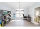 Bright office space featuring a desk, chair, shelving unit, and large windows, ideal for a home office setup at 8718 Canter Post Dr, Charlotte, NC 28216