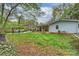 Large backyard featuring a fire pit, green lawn, covered patio, and beautiful landscaping at 9025 Shields Dr, Huntersville, NC 28078