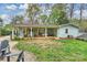 Lush backyard with mature trees, fire pit area, and view of the covered patio at 9025 Shields Dr, Huntersville, NC 28078