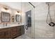 Stylish bathroom with double vanity, patterned wallpaper, glass shower, and decorative floor tiles at 9025 Shields Dr, Huntersville, NC 28078