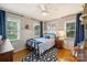 Cozy bedroom with hardwood floors, natural light, a ceiling fan, and a comfortable twin bed at 9025 Shields Dr, Huntersville, NC 28078
