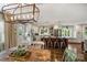 Bright kitchen boasts an island with seating, stainless appliances, and a lovely rustic light fixture above a dining table at 9025 Shields Dr, Huntersville, NC 28078