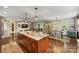 Open floorplan showing kitchen island, dining room, and living room with built in entertainment center at 9025 Shields Dr, Huntersville, NC 28078