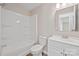 A full bathroom with white fixtures, including a toilet, vanity with a sink, and a tub/shower combo at 102 Lansdale Ave, Lincolnton, NC 28092