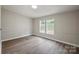 A bright bedroom with laminate flooring and wainscoting has two windows offering outside views at 102 Lansdale Ave, Lincolnton, NC 28092