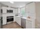 Updated kitchen with stainless steel appliances, white cabinets, and modern countertops with a large window at 102 Lansdale Ave, Lincolnton, NC 28092