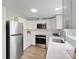 Modern kitchen features stainless steel appliances, white cabinets and countertops and woodgrain flooring at 102 Lansdale Ave, Lincolnton, NC 28092