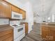 Kitchen features light wood cabinets and white appliances at 10441 Hugue Way, Charlotte, NC 28214