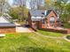 Expansive backyard featuring a brick home, detached garage, lush green lawn, and mature trees at 106 Berea Baptist Church Rd, Stanfield, NC 28163