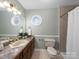 A bathroom with a wood vanity, white sink, and shower with a neutral color scheme at 106 Berea Baptist Church Rd, Stanfield, NC 28163