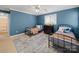 Stylish bedroom features blue walls, ceiling fan, two twin beds, and natural light at 106 Berea Baptist Church Rd, Stanfield, NC 28163