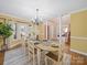 Bright dining room with wood floors, chandelier, and a view into a sunlit room and staircase at 106 Berea Baptist Church Rd, Stanfield, NC 28163