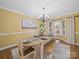 Charming dining area with a wooden table, bay window, and chandelier perfect for Gathering meals at 106 Berea Baptist Church Rd, Stanfield, NC 28163