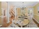 Elegant dining space features a wooden table, chandelier, and staircase with white pillars in the background at 106 Berea Baptist Church Rd, Stanfield, NC 28163