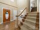 Inviting foyer with a decorative front door, staircase, and hardwood floors creates a warm welcome at 106 Berea Baptist Church Rd, Stanfield, NC 28163