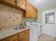 Convenient laundry room features granite countertop, tile backsplash, wooden cabinets, and modern appliances at 106 Berea Baptist Church Rd, Stanfield, NC 28163
