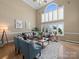 Open-concept living room with large windows, high ceilings, hardwood floors, comfortable seating, and natural light at 106 Berea Baptist Church Rd, Stanfield, NC 28163