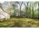 Large, green backyard with mature trees surrounding the property at 11100 Pine Grove Ave, Mint Hill, NC 28227