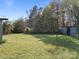 View of spacious, green backyard with mature trees and utility shed at 11170 Nc Hwy 73 E Hwy, Mount Pleasant, NC 28124