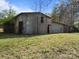 Exterior view of weathered barn with metal siding and overgrown vegetation at 11170 Nc Hwy 73 E Hwy, Mount Pleasant, NC 28124