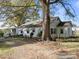 Exterior view of house with large tree in the yard and gravel driveway at 11170 Nc Hwy 73 E Hwy, Mount Pleasant, NC 28124