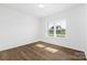 Bedroom with hardwood floors and a large window showcasing the community at 12437 Walker Dr # 89, Stanfield, NC 28163