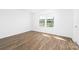 Bedroom with hardwood floors and a large window showcasing the community at 12437 Walker Dr # 89, Stanfield, NC 28163