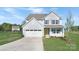 Charming two-story home featuring a welcoming front porch, attached two-car garage, and freshly landscaped yard at 12437 Walker Dr # 89, Stanfield, NC 28163