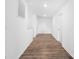 Clean hallway featuring wood-look floors and white walls at 12437 Walker Dr # 89, Stanfield, NC 28163