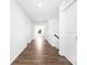 Bright hallway featuring wood-look flooring and white walls leading towards a well-lit open space at 12437 Walker Dr # 89, Stanfield, NC 28163