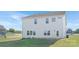 Rear exterior view featuring a light gray two-story house, windows, and well-maintained lawn at 12437 Walker Dr # 89, Stanfield, NC 28163