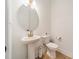 Powder room with a pedestal sink, modern fixtures, and wood flooring at 1402 Encore Ln, Waxhaw, NC 28173