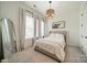 Bright bedroom featuring a neutral color palette, stylish light fixture, and large windows with lots of natural light at 1402 Encore Ln, Waxhaw, NC 28173