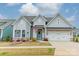 Charming home featuring a craftsman style elevation, two-car garage, a well-manicured lawn, and patriotic decor at 1402 Encore Ln, Waxhaw, NC 28173