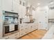 Modern kitchen with stainless appliances, stylish white cabinetry, herringbone backsplash, and hardwood flooring at 1402 Encore Ln, Waxhaw, NC 28173