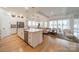 An open-concept kitchen boasts a large island with bar seating, stainless appliances, and hardwood floors at 1402 Encore Ln, Waxhaw, NC 28173