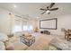 Living room featuring ample windows, ceiling fan, and projector screen for watching movies at 1402 Encore Ln, Waxhaw, NC 28173
