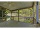 Covered back porch boasts ceiling fan overlooking tiered back yard landscape with lush green space and mature trees at 14103 Grand Traverse Dr, Charlotte, NC 28278