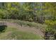 Professionally landscaped back yard has lush green grass and tiered retaining walls with assorted mature trees and foliage at 14103 Grand Traverse Dr, Charlotte, NC 28278