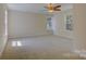 Well-lit bedroom with neutral carpet and walls featuring large windows and a ceiling fan at 14103 Grand Traverse Dr, Charlotte, NC 28278