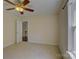 Bedroom featuring a ceiling fan and a door that leads to a wooden staircase at 14103 Grand Traverse Dr, Charlotte, NC 28278
