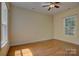 A light-filled bedroom with hardwood floors, a ceiling fan, and a large window at 14103 Grand Traverse Dr, Charlotte, NC 28278