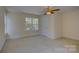 Bright bedroom featuring neutral walls and carpet with a ceiling fan and a view of the outside at 14103 Grand Traverse Dr, Charlotte, NC 28278
