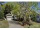 Exterior showcasing a tan two-story home, attached garage, and a long driveway at 14103 Grand Traverse Dr, Charlotte, NC 28278