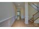 Welcoming foyer with hardwood floors, wainscoting, and a staircase leading to the upper level at 14103 Grand Traverse Dr, Charlotte, NC 28278