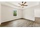 Bedroom featuring wood-look floors, neutral walls, ceiling fan and window showcasing the outdoor greenery at 1451 Cherryville Rd, Shelby, NC 28150