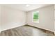 Bright bedroom with light-colored walls, grey floors, and a window showcasing the outdoor greenery at 1451 Cherryville Rd, Shelby, NC 28150