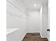 Walk-in closet features clean white walls, wood-look flooring, and open shelving for optimal storage solutions at 1451 Cherryville Rd, Shelby, NC 28150