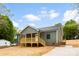 Green sided home with a charming wooden porch, convenient access stairs, and a concrete driveway at 1451 Cherryville Rd, Shelby, NC 28150