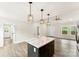 Open concept kitchen with island and modern pendant lights, leading to living area with bright windows at 1451 Cherryville Rd, Shelby, NC 28150